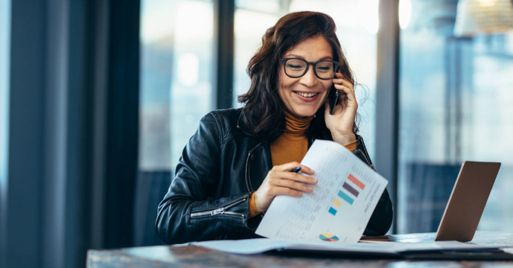 A finance leader analyzing charts and graphs while speaking on the phone, representing strategic decision-making in data protection.