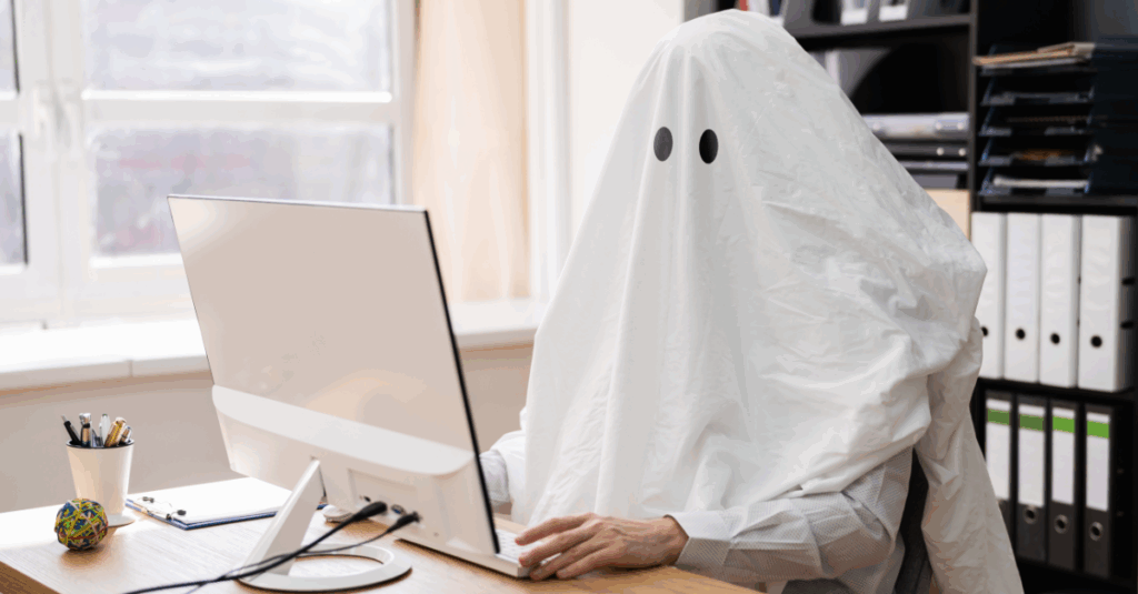 finance leader wearing a ghost costume at a desk with a computer